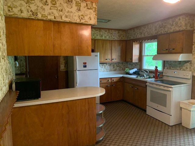 101 Gale Ct, Circleville, OH 43113 - kitchen featuring white appliances, wallpapered walls, under cabinet range hood, a sink, and brown cabinetry