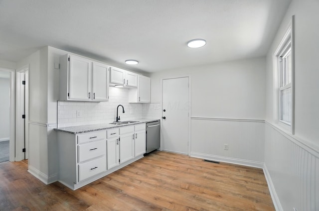 1410 E Dublin Granville Rd, Columbus, OH 43229 - kitchen featuring a sink, stainless steel dishwasher, light wood-style flooring, light stone countertops, and wainscoting