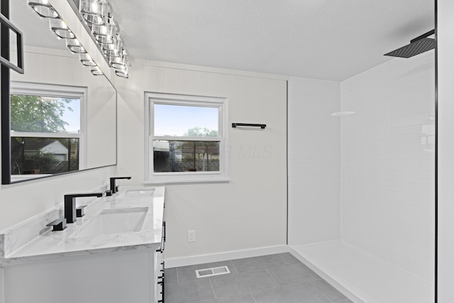 1116 S Yearling Rd, Columbus, OH 43227 - full bath featuring tile patterned floors, double vanity, healthy amount of natural light, a tile shower, and a textured ceiling