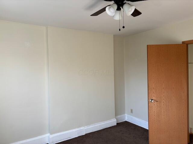 411 Berkeley Rd, Columbus, OH 43205 - empty room with dark colored carpet, ceiling fan, and baseboards
