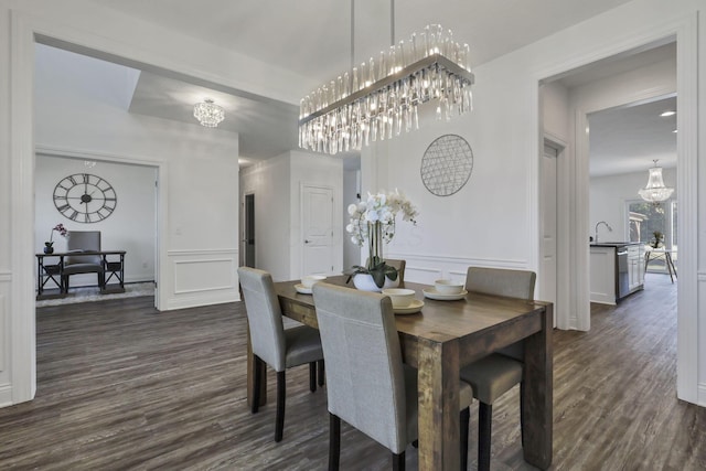7578 Hastings St, Pickerington, OH 43147 - dining space featuring a chandelier, dark wood finished floors, a decorative wall, and a wainscoted wall