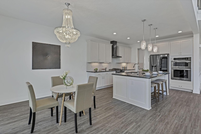 7578 Hastings St, Pickerington, OH 43147 - kitchen featuring appliances with stainless steel finishes, dark countertops, wood finished floors, a chandelier, and backsplash