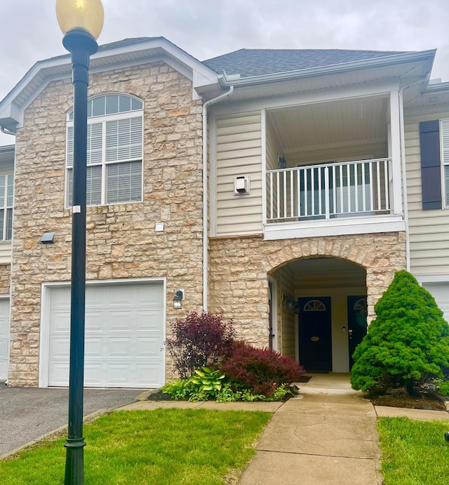 4960 Ivyvine Blvd, Dublin, OH 43016 - view of front of property with a balcony, stone siding, an attached garage, and driveway
