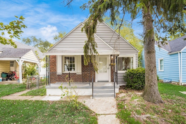 1052 Geers Ave, Columbus, OH 43206 - bungalow with brick siding, a porch, and a front yard