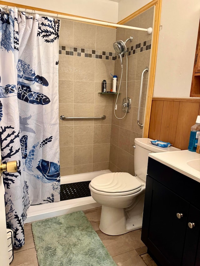1150 Bermuda Dr, Marion, OH 43302 - bathroom featuring toilet, vanity, a tile shower, tile patterned flooring, and wainscoting