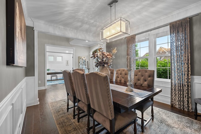 3624 Sparrow Ct, Hilliard, OH 43026 - dining space featuring dark wood-style floors, crown molding, a chandelier, a decorative wall, and wainscoting