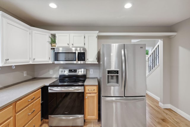 7700 State Route 61, Sunbury, OH 43074 - kitchen with appliances with stainless steel finishes, white cabinetry, light wood-type flooring, recessed lighting, and light countertops