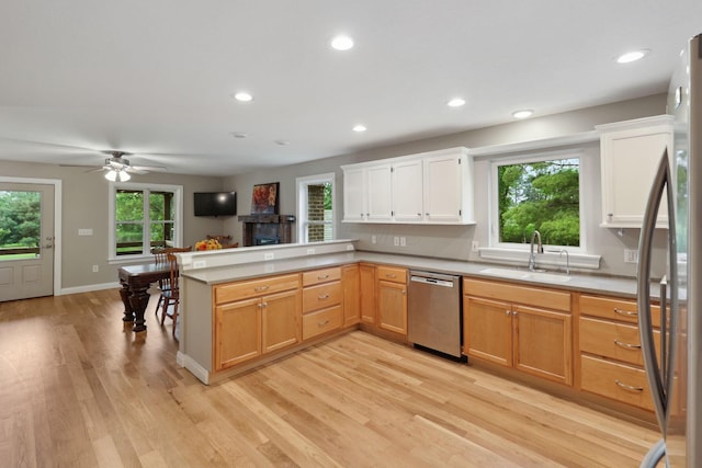 7700 State Route 61, Sunbury, OH 43074 - kitchen featuring stainless steel appliances, a sink, a peninsula, light wood finished floors, and light countertops