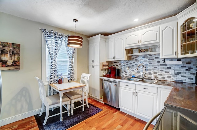 8448 Blue Lake Ave, Galloway, OH 43119 - kitchen featuring stainless steel dishwasher, a sink, tasteful backsplash, light wood-type flooring, and white cabinetry