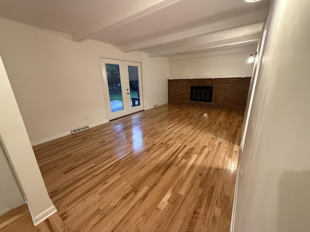 460 Blandings Ct, Worthington, OH 43085 - unfurnished living room featuring french doors, beam ceiling, light wood-style flooring, and a fireplace