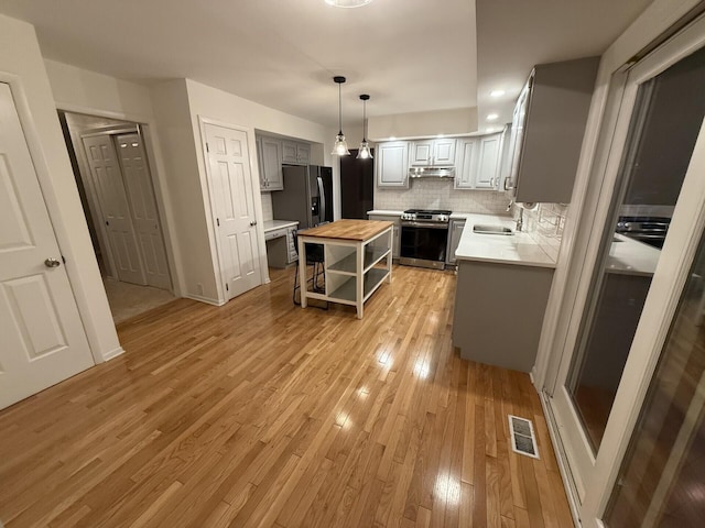 460 Blandings Ct, Worthington, OH 43085 - kitchen with appliances with stainless steel finishes, wood counters, open shelves, under cabinet range hood, and light wood-style floors