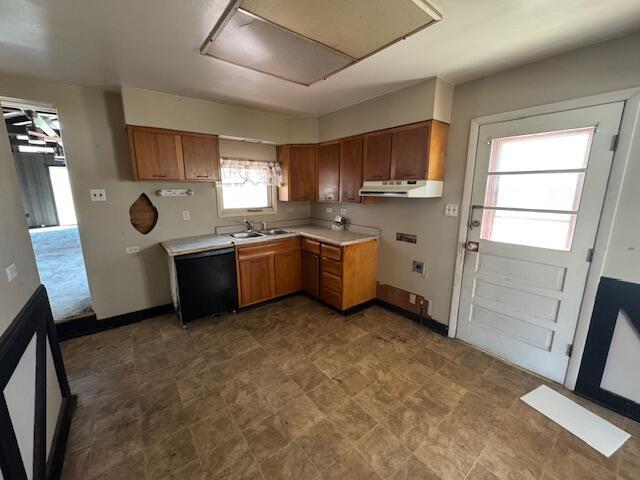 68511 Liston Ave, Bridgeport, OH 43912 - kitchen featuring under cabinet range hood, brown cabinetry, light countertops, a sink, and dishwasher