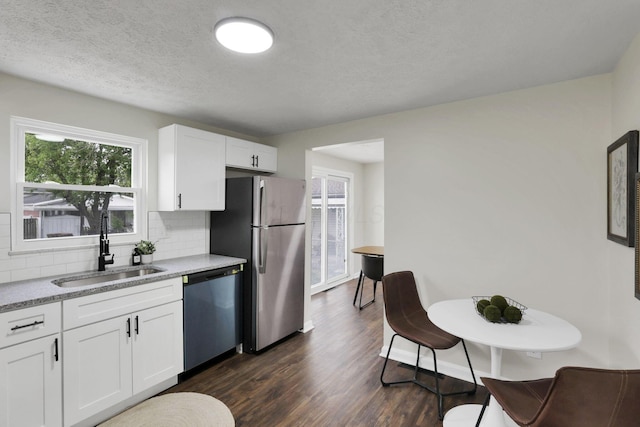 1465 Zenner Dr, Columbus, OH 43207 - kitchen with dishwasher, freestanding refrigerator, a sink, tasteful backsplash, and healthy amount of natural light