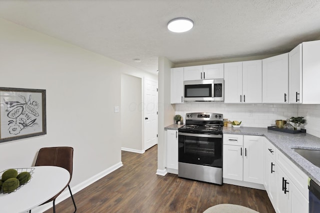 1465 Zenner Dr, Columbus, OH 43207 - kitchen with appliances with stainless steel finishes, tasteful backsplash, dark wood-style flooring, baseboards, and white cabinets