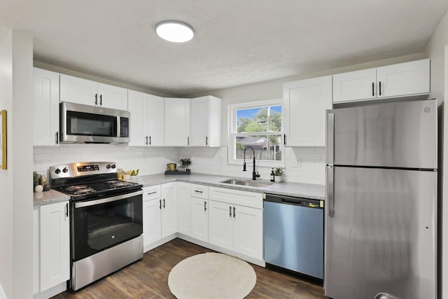 1465 Zenner Dr, Columbus, OH 43207 - kitchen featuring appliances with stainless steel finishes, a sink, white cabinetry, light countertops, and decorative backsplash