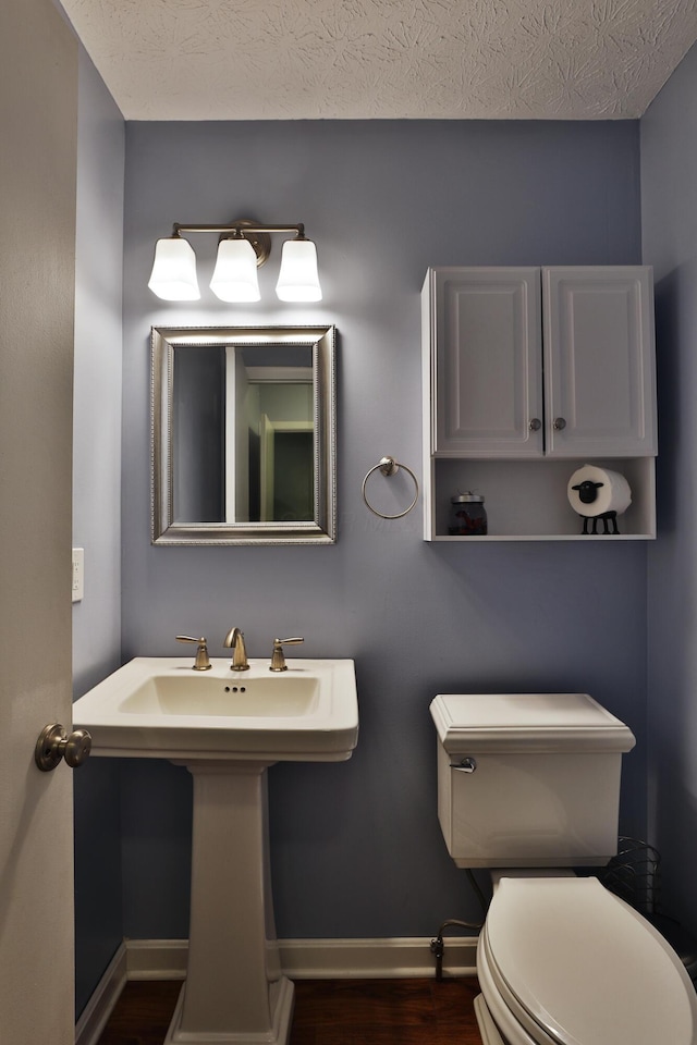 4359 Shire Cove Rd, Hilliard, OH 43026 - half bathroom with wood finished floors, toilet, baseboards, and a textured ceiling