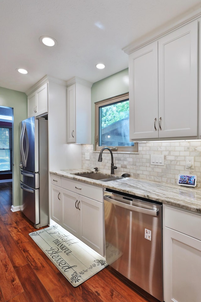 4359 Shire Cove Rd, Hilliard, OH 43026 - kitchen with appliances with stainless steel finishes, a sink, dark wood-style floors, decorative backsplash, and white cabinets