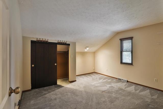 4359 Shire Cove Rd, Hilliard, OH 43026 - unfurnished bedroom with a textured ceiling, carpet floors, lofted ceiling, and a closet