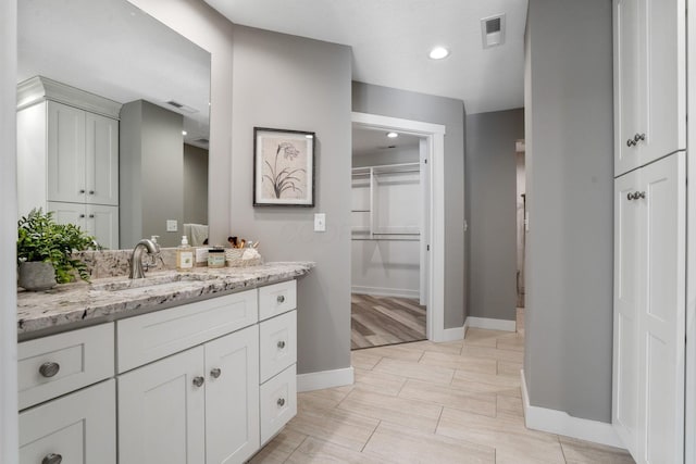 107 Willows End, Bellefontaine, OH 43311 - bathroom with vanity, baseboards, a walk in closet, and recessed lighting
