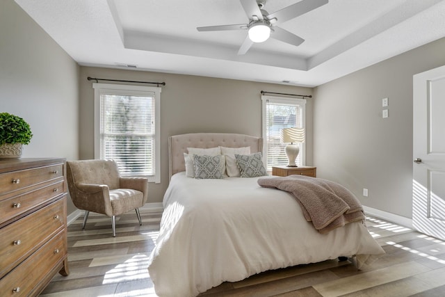 107 Willows End, Bellefontaine, OH 43311 - bedroom featuring light wood-style floors, a tray ceiling, baseboards, and ceiling fan