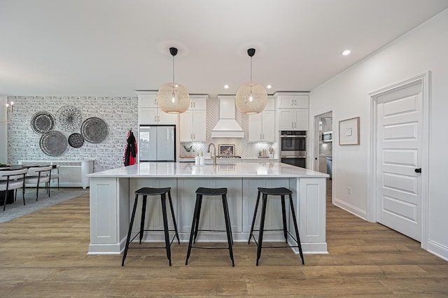 2733 Sycamore Trce, Hilliard, OH 43026 - kitchen featuring fridge, custom exhaust hood, stainless steel double oven, white cabinetry, and recessed lighting