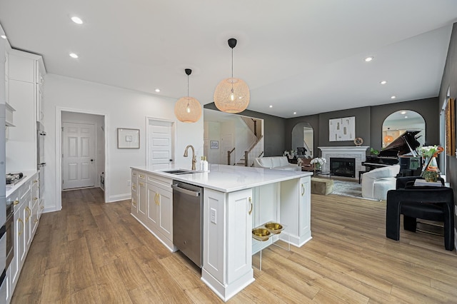 2733 Sycamore Trce, Hilliard, OH 43026 - kitchen with appliances with stainless steel finishes, a sink, white cabinetry, light wood-style floors, and open floor plan