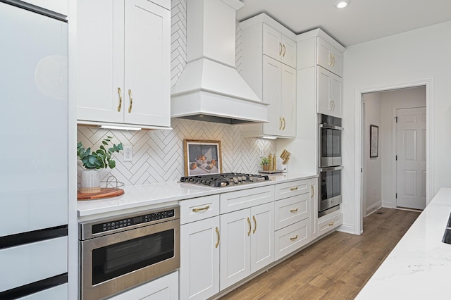 2733 Sycamore Trce, Hilliard, OH 43026 - kitchen with premium range hood, appliances with stainless steel finishes, wood finished floors, tasteful backsplash, and recessed lighting