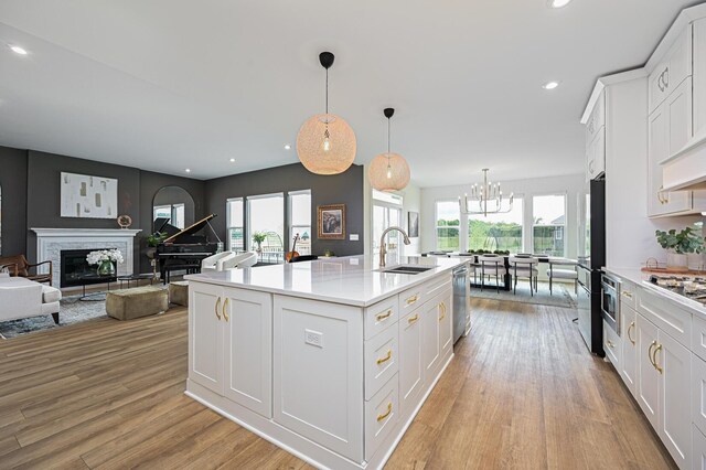 2733 Sycamore Trce, Hilliard, OH 43026 - kitchen with a sink, stainless steel appliances, a chandelier, light wood finished floors, and recessed lighting