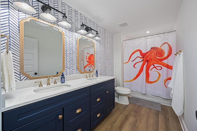 2733 Sycamore Trce, Hilliard, OH 43026 - full bath featuring wallpapered walls, double vanity, toilet, wood finished floors, and an accent wall