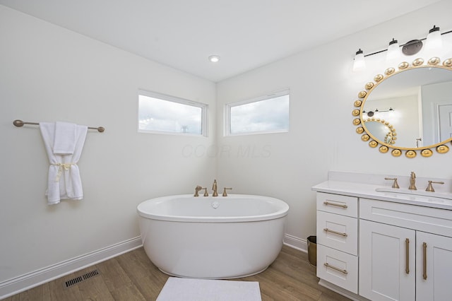 2733 Sycamore Trce, Hilliard, OH 43026 - bathroom with vanity, a soaking tub, wood finished floors, and baseboards