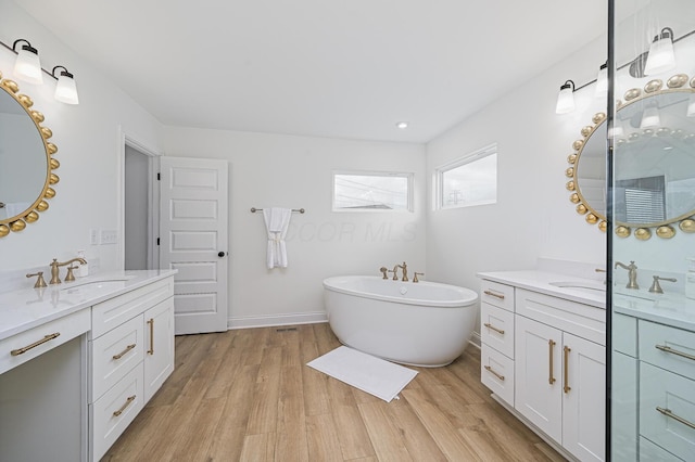 2733 Sycamore Trce, Hilliard, OH 43026 - full bathroom with two vanities, a freestanding bath, wood finished floors, and recessed lighting