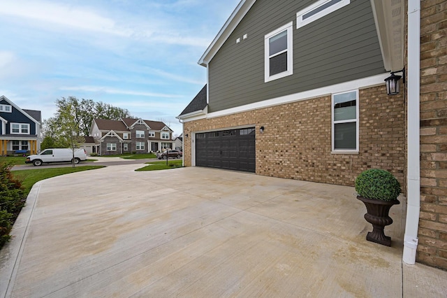 2733 Sycamore Trce, Hilliard, OH 43026 - view of side of home with an attached garage, driveway, brick siding, and a residential view
