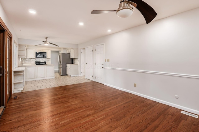 1609 Slade Ave, Columbus, OH 43235 - unfurnished living room featuring a ceiling fan, light wood-style floors, baseboards, recessed lighting, and a sink