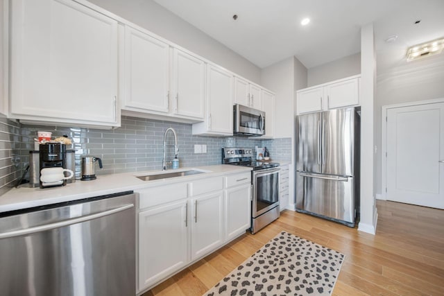825 N 4th St Unit 406, Columbus, OH 43215 - kitchen with stainless steel appliances, a sink, white cabinets, light countertops, and tasteful backsplash