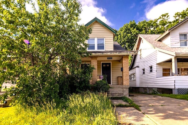 3102 Lehman Rd, Cincinnati, OH 45204 - view of front of house with covered porch, a shingled roof, and brick siding