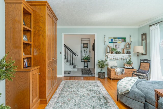 4561 Bent Creek Pl, Grove City, OH 43123 - sitting room featuring ornamental molding, wood finished floors, stairs, baseboards, and a textured ceiling
