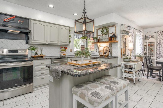 4561 Bent Creek Pl, Grove City, OH 43123 - kitchen featuring stainless steel appliances, backsplash, a kitchen island, hanging light fixtures, and a textured ceiling