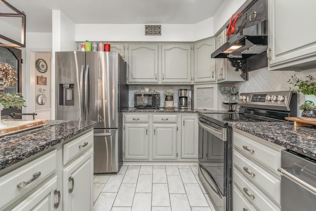 4561 Bent Creek Pl, Grove City, OH 43123 - kitchen featuring stainless steel appliances, tasteful backsplash, under cabinet range hood, and dark stone counters