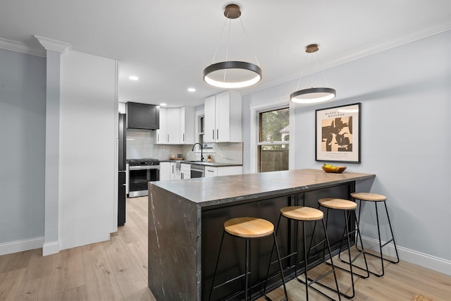 2583 Wexford Rd, Columbus, OH 43221 - kitchen with appliances with stainless steel finishes, a peninsula, dark countertops, light wood-type flooring, and a sink