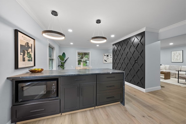 2583 Wexford Rd, Columbus, OH 43221 - kitchen with black microwave, light wood finished floors, ornamental molding, baseboards, and decorative light fixtures