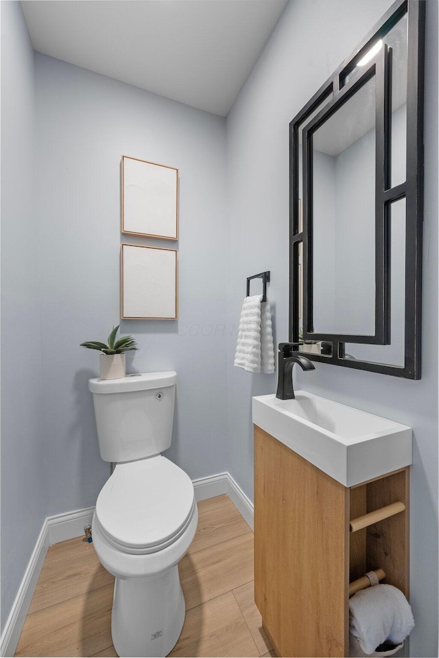2583 Wexford Rd, Columbus, OH 43221 - half bathroom with vanity, baseboards, toilet, and wood finished floors