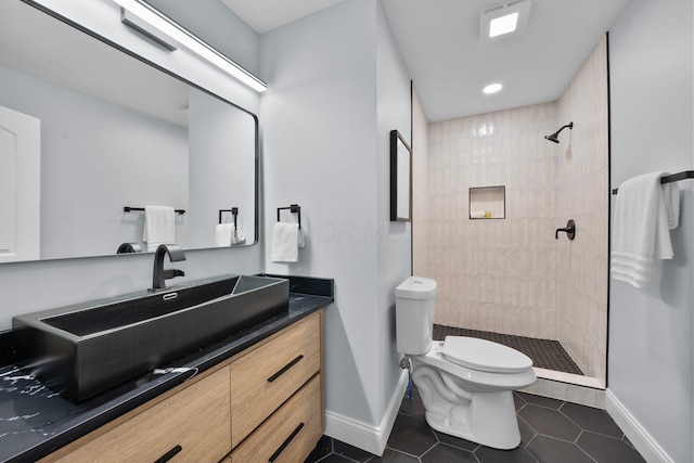2583 Wexford Rd, Columbus, OH 43221 - full bathroom with baseboards, tile patterned flooring, vanity, a tile shower, and toilet
