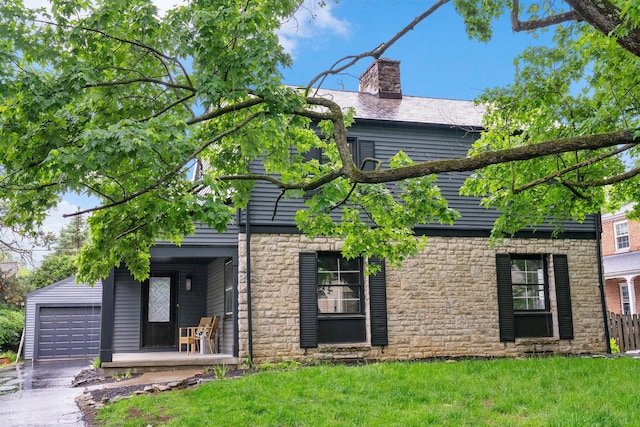 2583 Wexford Rd, Columbus, OH 43221 - view of front of house with stone siding, a garage, a front lawn, a chimney, and asphalt driveway