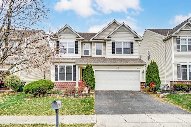 2697 Rinaldi Dr, Columbus, OH 43219 - view of front facade with brick siding, asphalt driveway, a garage, a front lawn, and roof with shingles