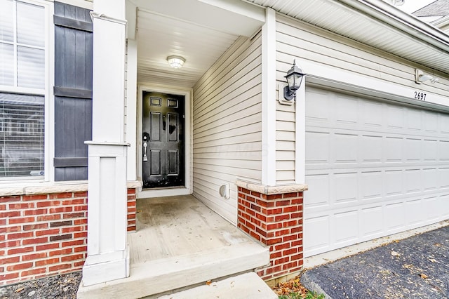 2697 Rinaldi Dr, Columbus, OH 43219 - property entrance featuring a garage, a porch, and driveway