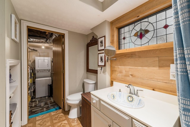 796 Mulberry Dr, Columbus, OH 43235 - bathroom featuring stacked washing machine and dryer, vanity, and toilet