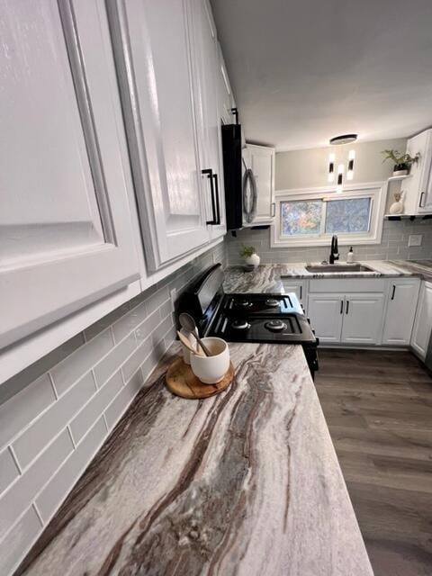 79 N Main St, Jeffersonville, OH 43128 - kitchen featuring stainless steel microwave, a sink, backsplash, and white cabinets