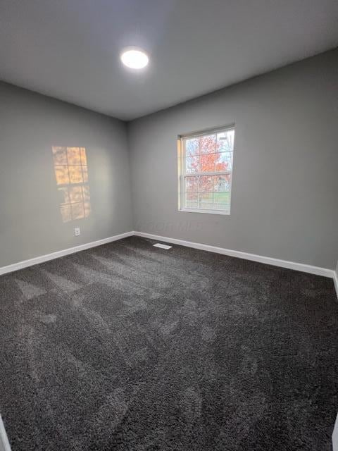 79 N Main St, Jeffersonville, OH 43128 - unfurnished room featuring baseboards and dark carpet