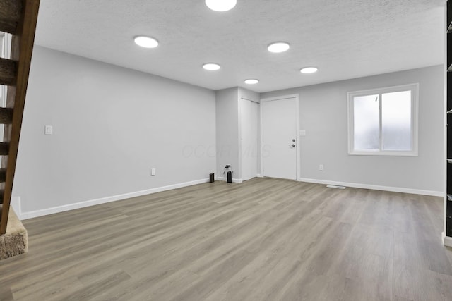 2505 Burgandy Ln Unit C, Columbus, OH 43232 - unfurnished living room featuring a textured ceiling, wood finished floors, and baseboards