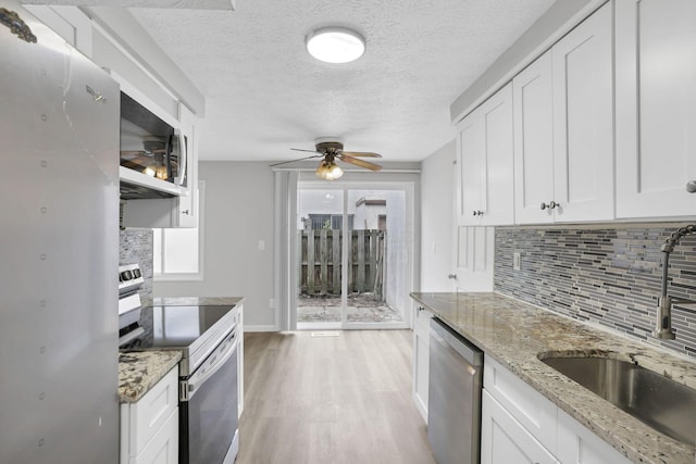 2505 Burgandy Ln Unit C, Columbus, OH 43232 - kitchen featuring electric range, stainless steel dishwasher, a sink, white microwave, and decorative backsplash